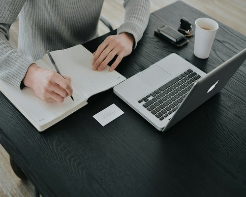 Person preparing notes on a desk before a medical appointment